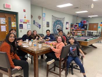 children at a table playing board games and eating snacks and drinking water