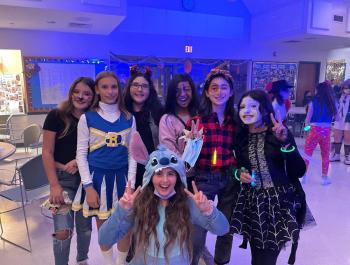 teens standing and posing for photo while dressed for halloween